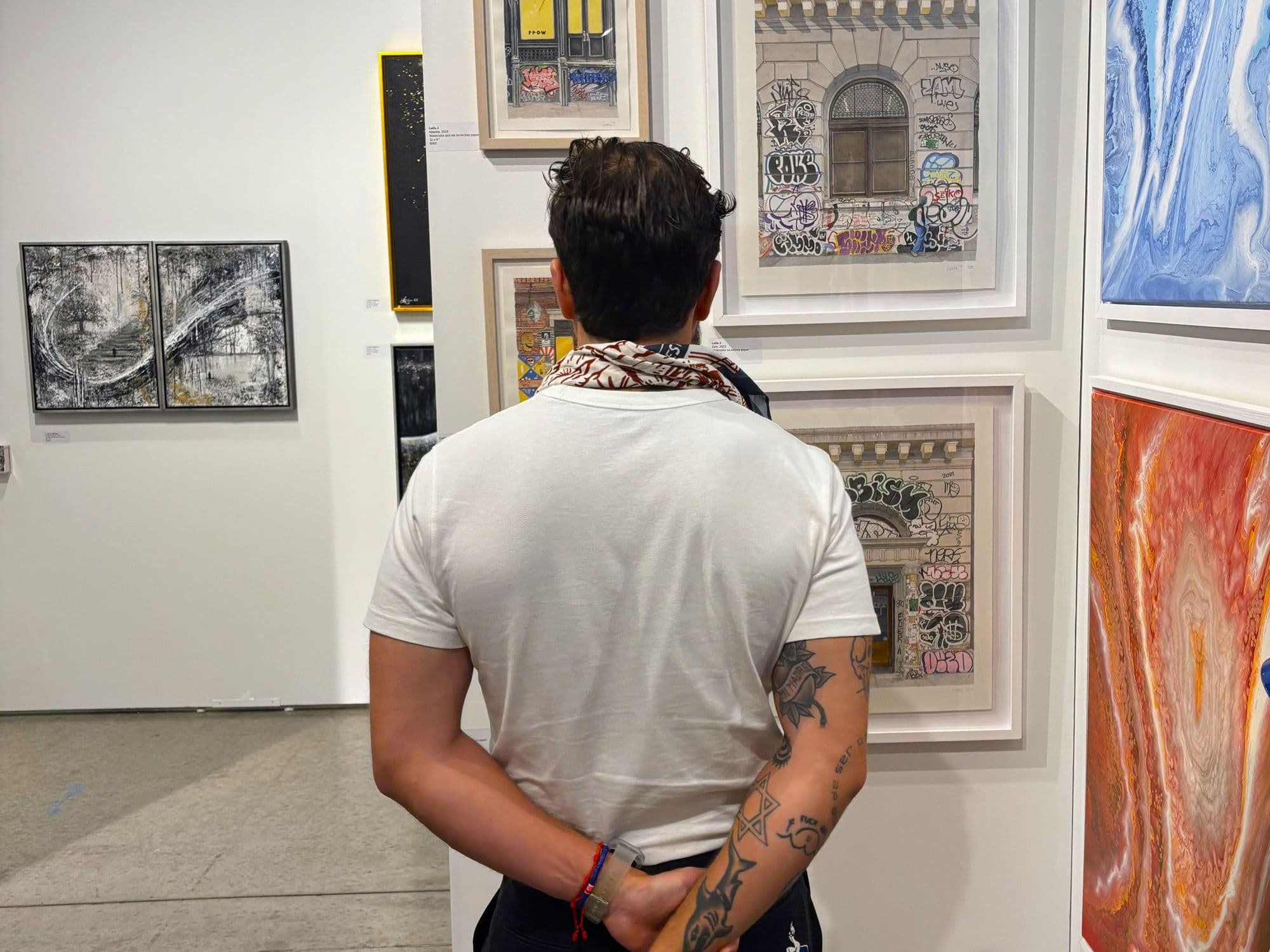 A visitor viewing framed works on a gallery wall