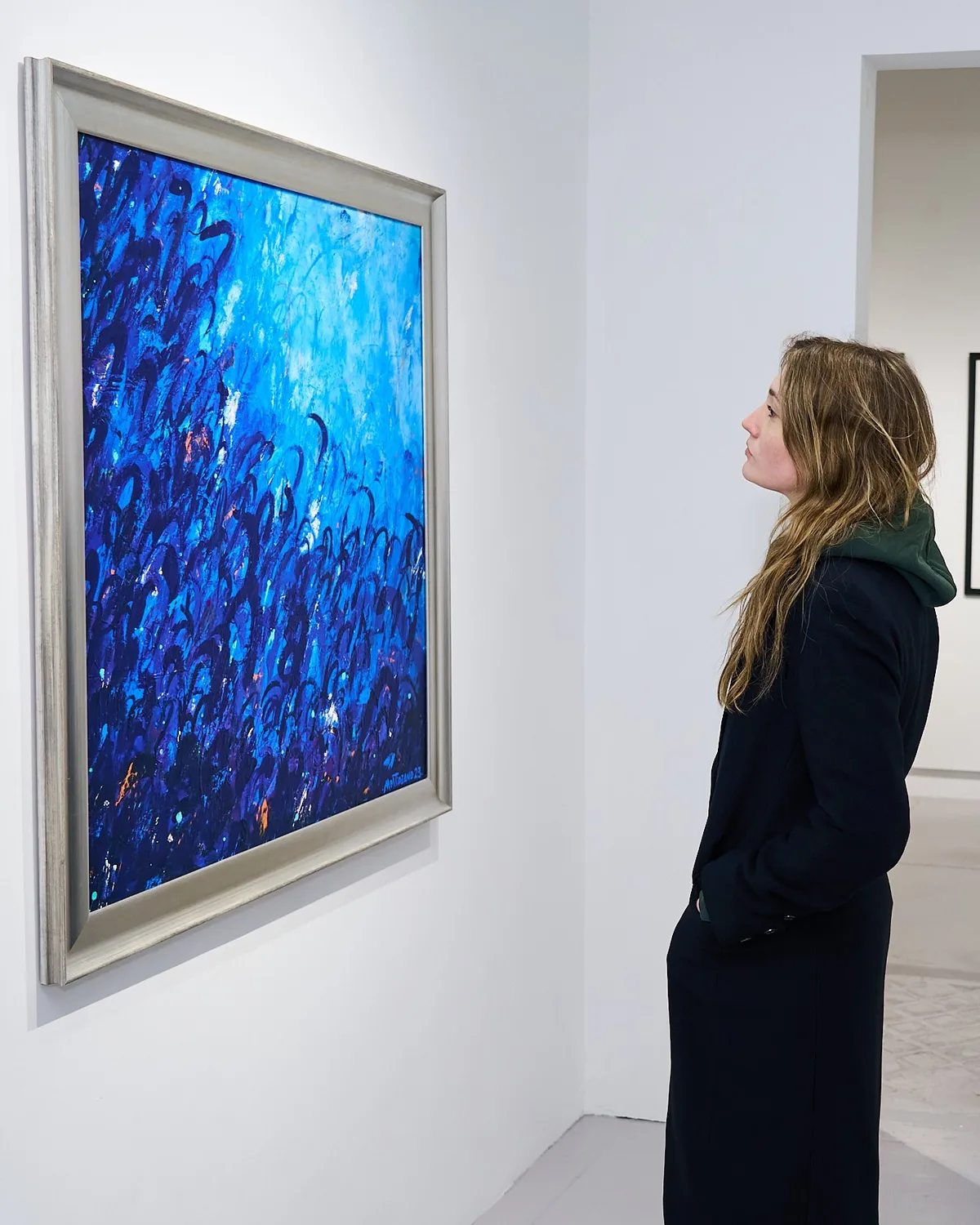A visitor looking at a large blue abstract painting at a previous A New Gotham exhibition, Agora Gallery, Chelsea