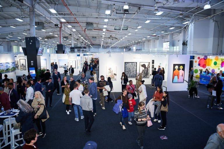 Visitors walking an art fair floor