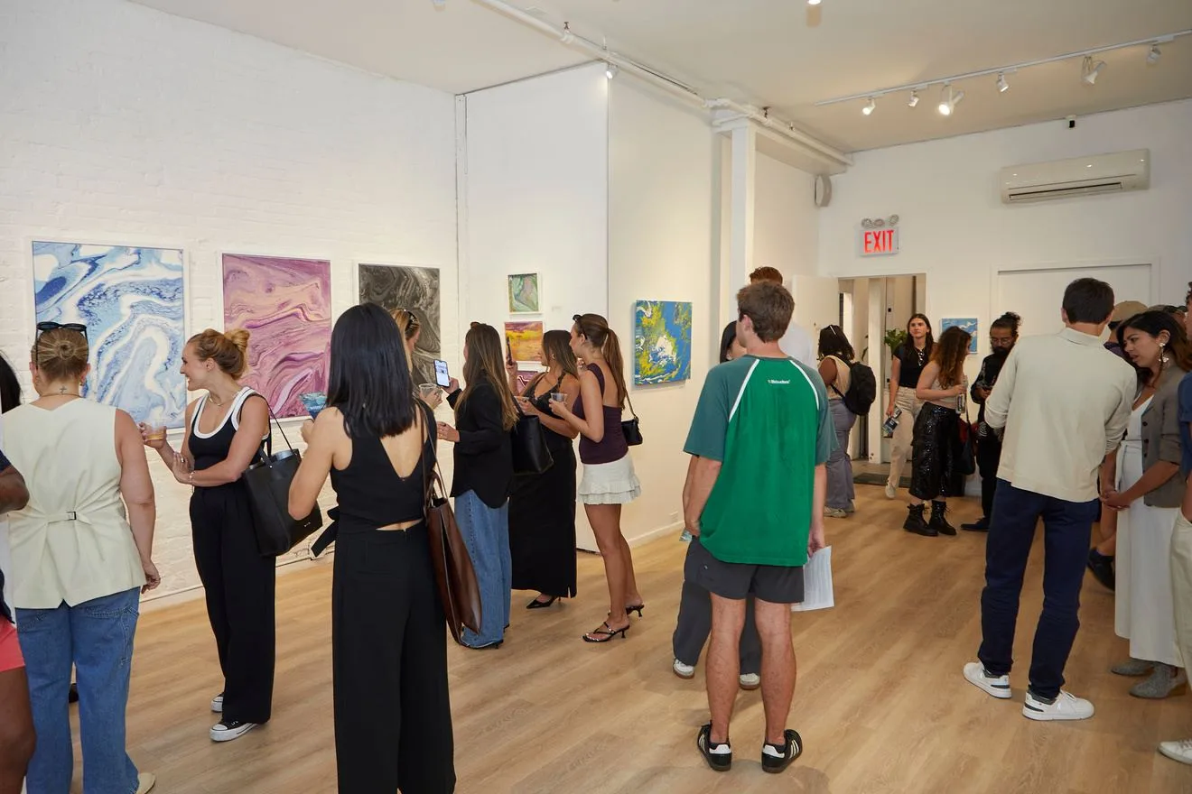 Guests viewing art at an opening reception in a Chelsea gallery space
