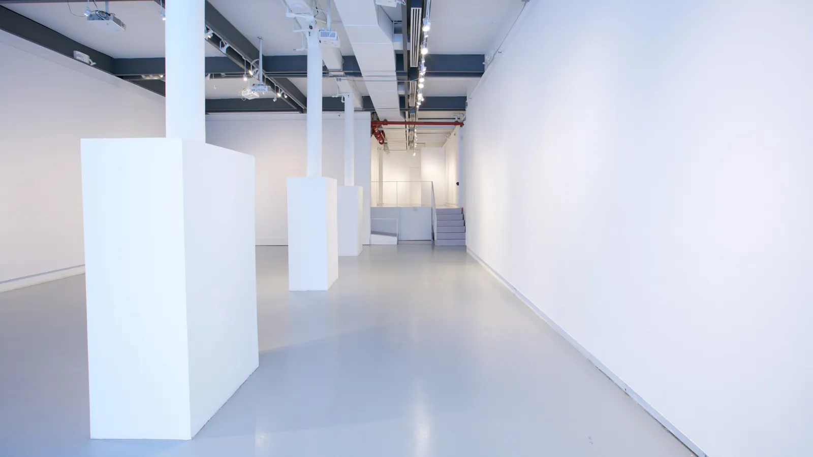 A long view down the 530 West 25th Street gallery towards the staircase and metal handrail up to the mezzanine