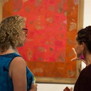 Dos personas hablando en una galería de arte.