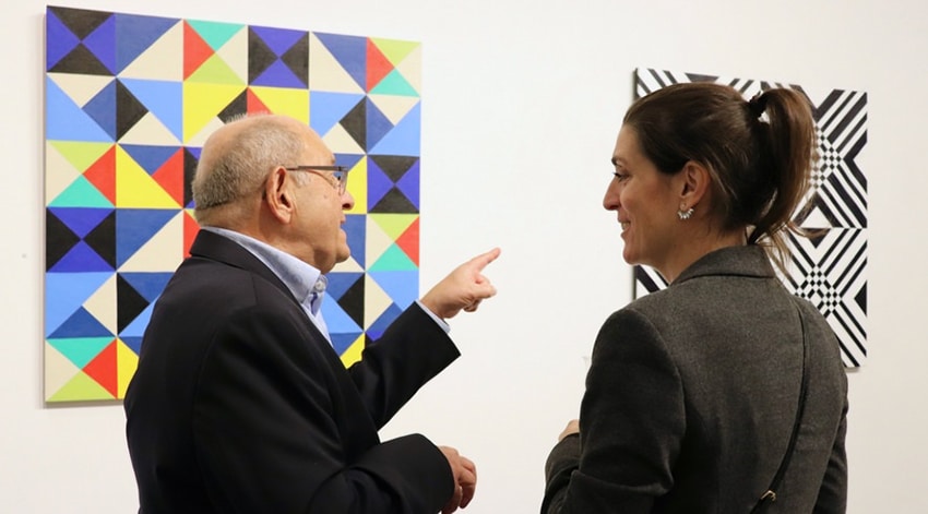 El artista Osvaldo Bacman hablando de sus obras con visitantes en la galería
