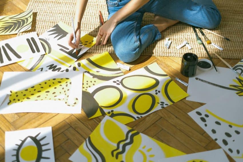 Artist sitting on the floor while painting