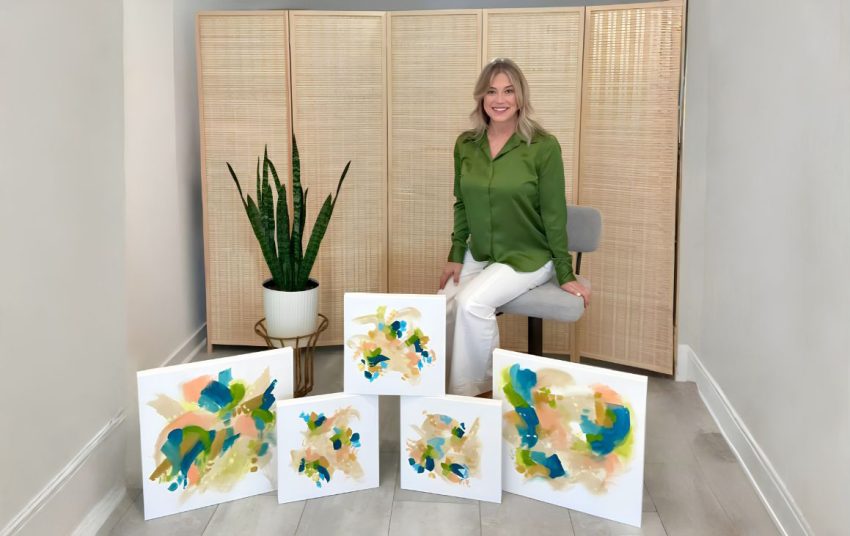 Artist Sherri Springer posing with her abstract paintings in her home studio