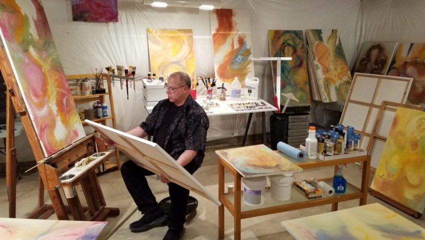 Second-career artist Harry Burleigh painting in his studio after working in corporate television.