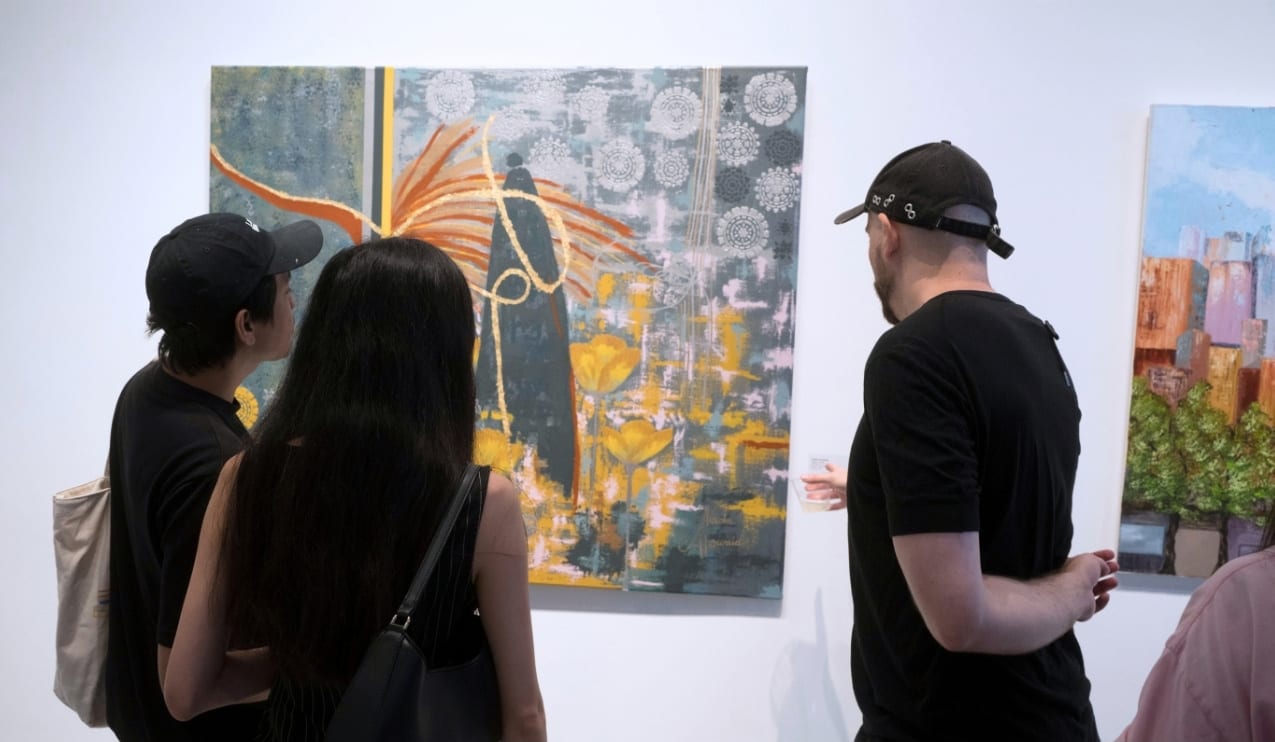 Visitors discussing artwork during AGI Fine Art's Summer City Idyll exhibition