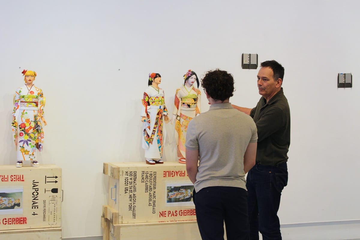 Artist Marc Ringaud with a gallery team member beside his kimono-clad sculptures on their labeled shipping crates at Agora Gallery