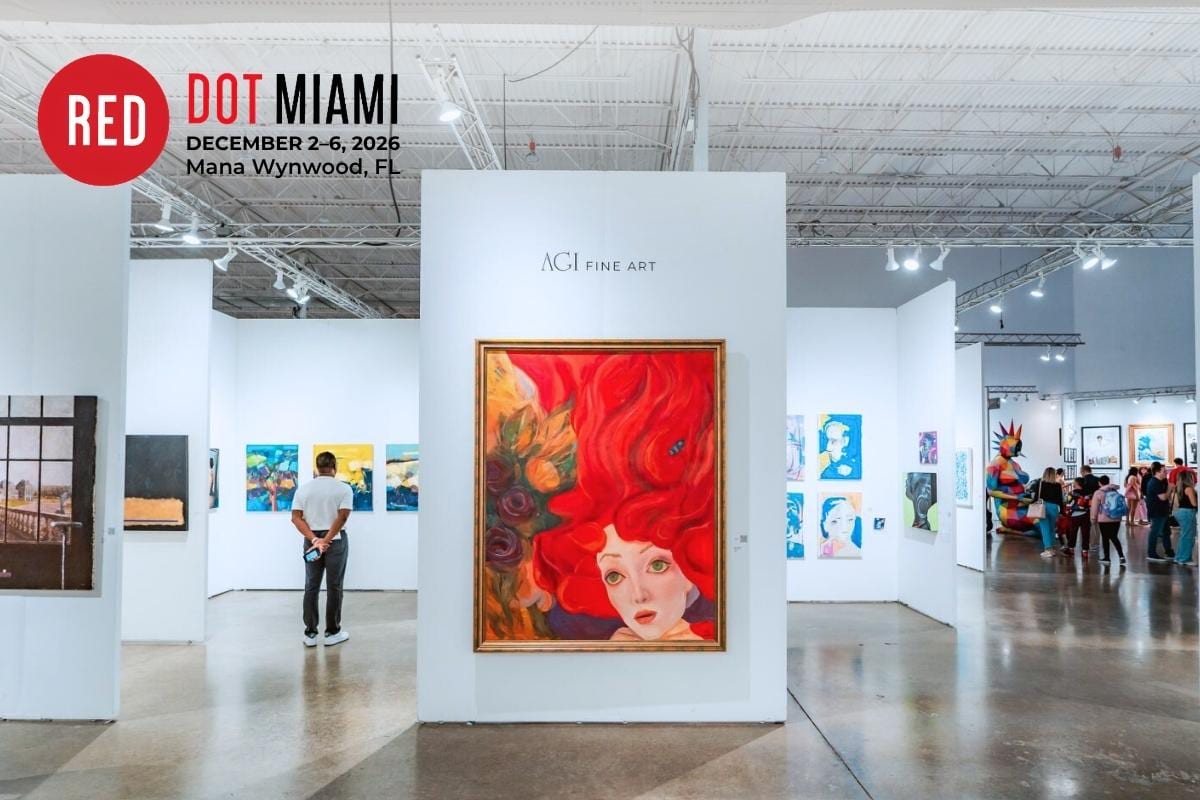 AGI Fine Art’s booth at Red Dot Miami during Miami Art Week, featuring a large portrait of a woman with flowing red hair as a visitor views works nearby.